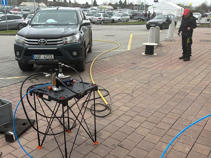 Cable blowing machine and fibre cable in the duct across a retail park car park