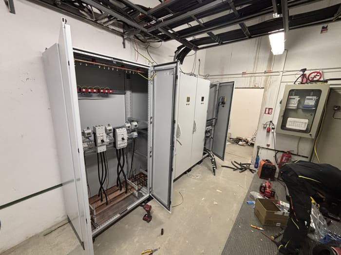 New switchboard sections with doors open during installation
