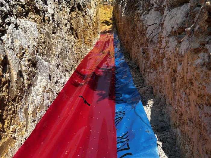 Red and blue warning foil side by side in the trench