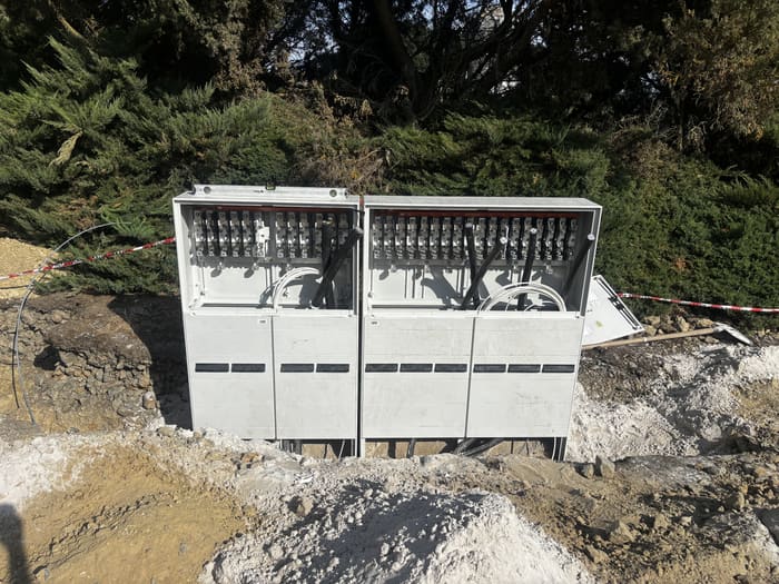 Two distribution cabinets with the doors open, standing over the cables in the pit