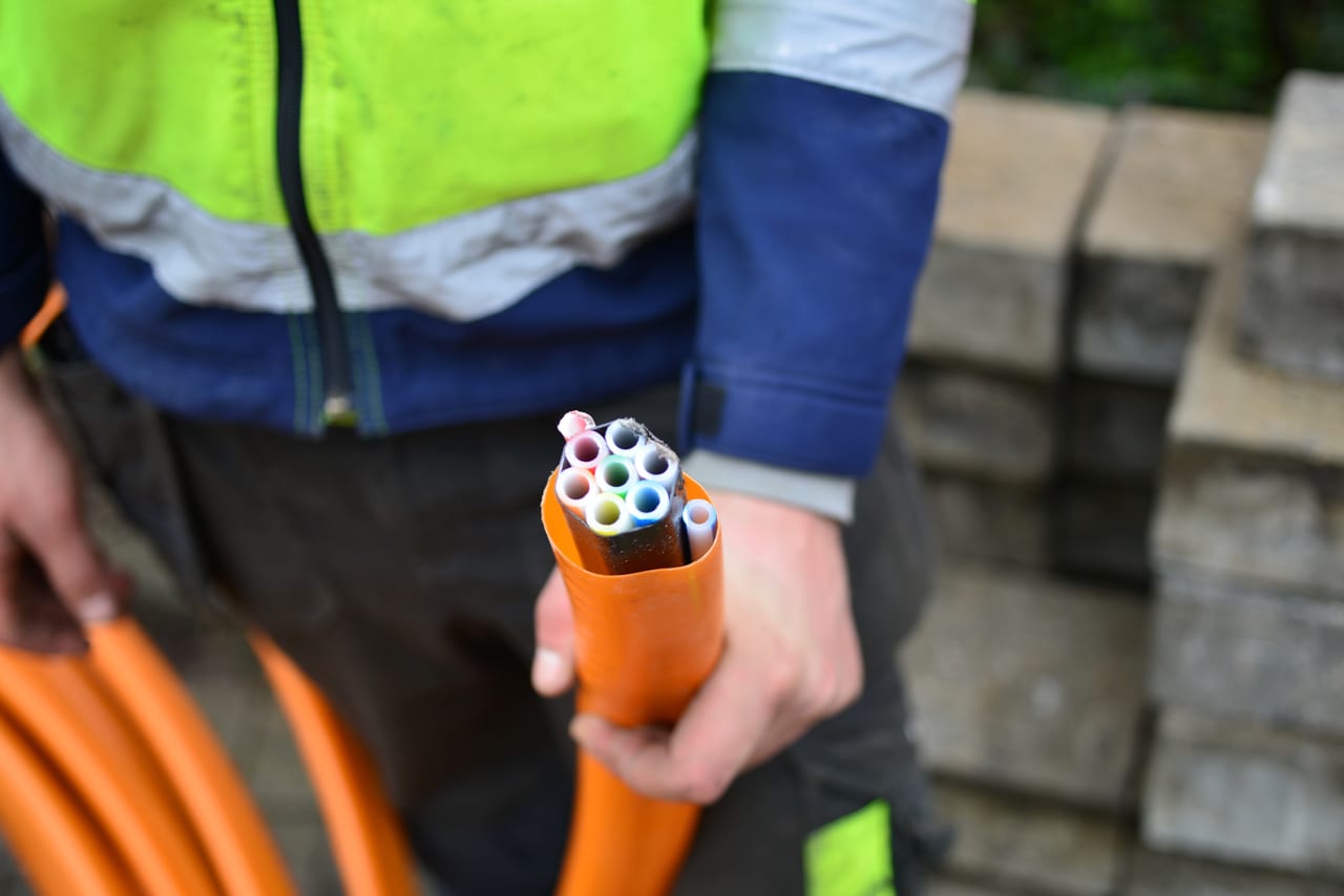Cut HDPE duct with coloured microducts in an installer’s hand